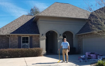 Pride Roofing LLC owner standing in front of residential property featuring a recent shingle roof installation