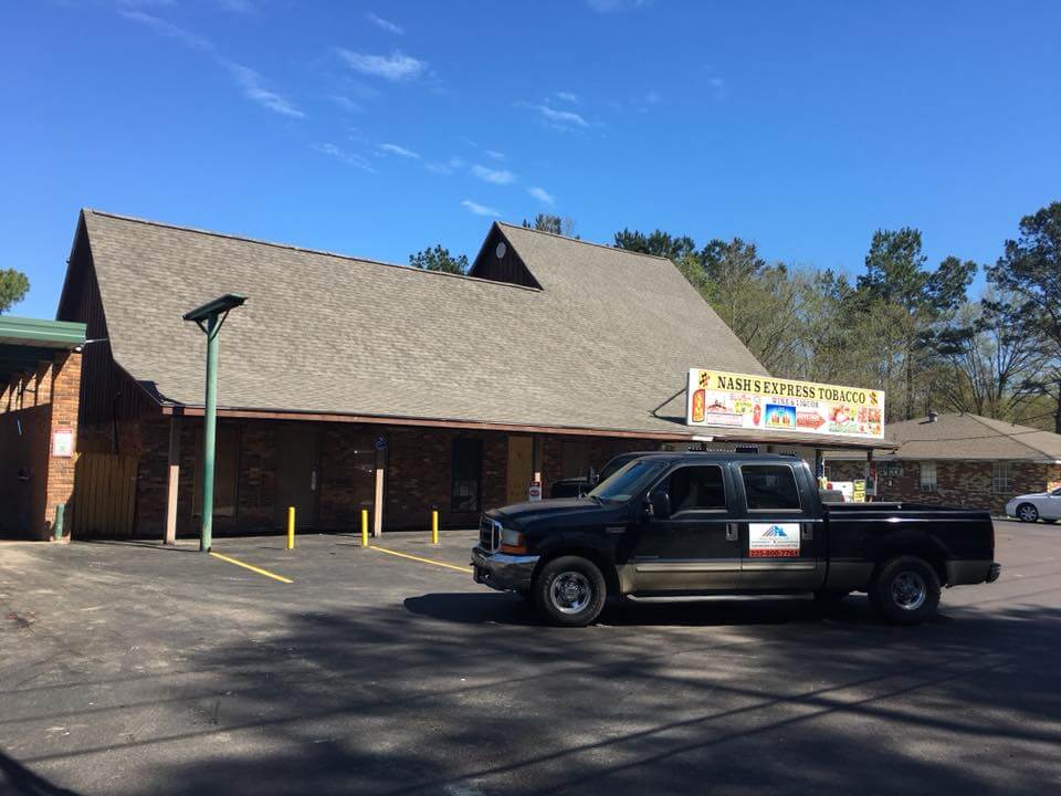 Truck with Pride Roofing LLC magnet on the door parked in front of a Restaurant with shingle roofing installed by Pride Roofing LLC