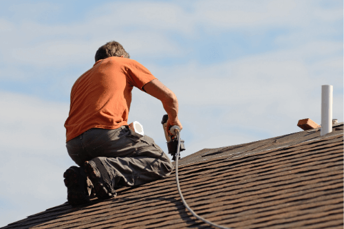 Pride Roofing LLC construction worker installing shingles onto roof