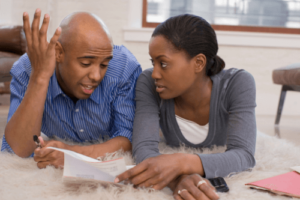Roof Replacement Costs - The Real Numbers in Albany La. with Pride Roofing LLC image of young african american couple going over numbers not understanding