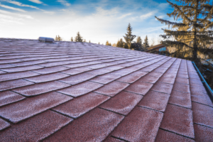 spring roof maintenance, roofing and construction expert in Hammond, LA at Pride Roofing LLC. A close-up view of a residential roof with a thin layer of frost.
