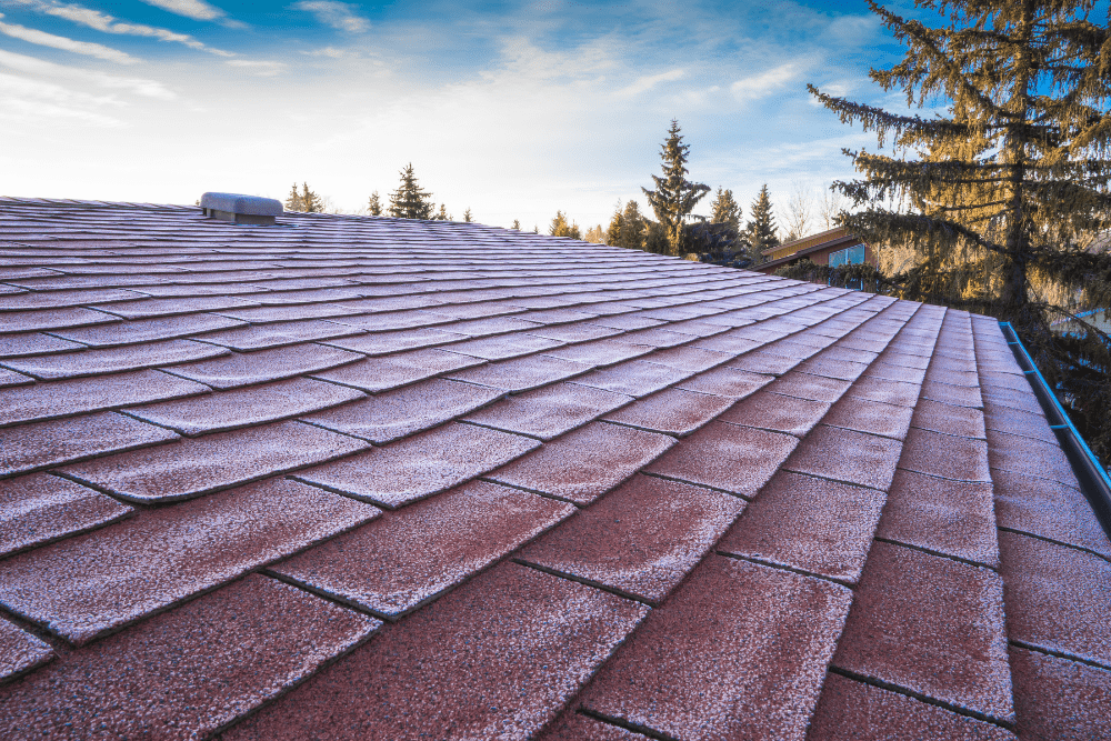 spring roof maintenance, roofing and construction expert in Hammond, LA at Pride Roofing LLC. A close-up view of a residential roof with a thin layer of frost.
