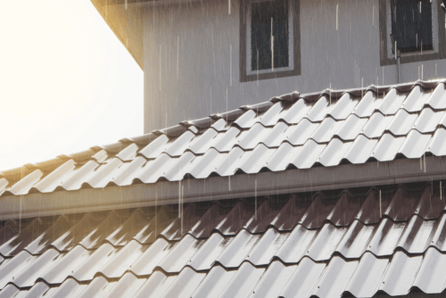 Roof repair in Hammond, LA by Pride Roofing LLC. Image of a metal roof during rainfall, highlighting durable roofing materials designed to protect homes from heavy rain, moisture intrusion, and long-term weather damage.